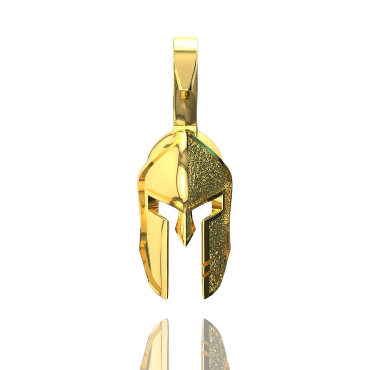 The 14k Gold Heroic Spartan Helmet Pendant features polished and textured details, displayed on a white background with a subtle reflection—a bold statement of Spartan-inspired jewelry.