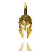 The Half-Face Diamond Spartan Helmet Pendant in 14K Gold is shaped like a Greek helmet and shown upright on a white background with its reflection below.