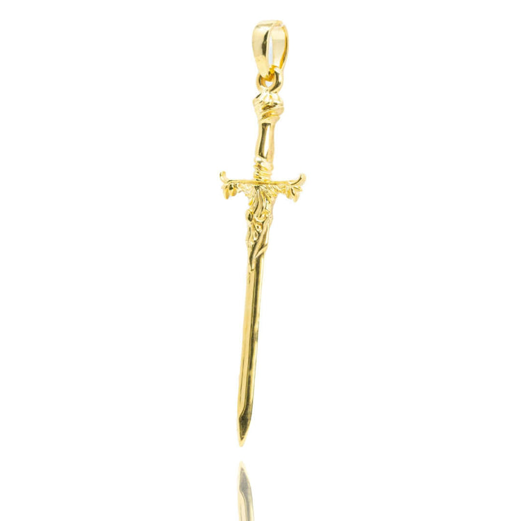 The 14k Gold Sword Pendant features a detailed sword design with an ornate hilt and a top loop for a chain, shown on a white background—a bold statement piece of warrior jewelry.