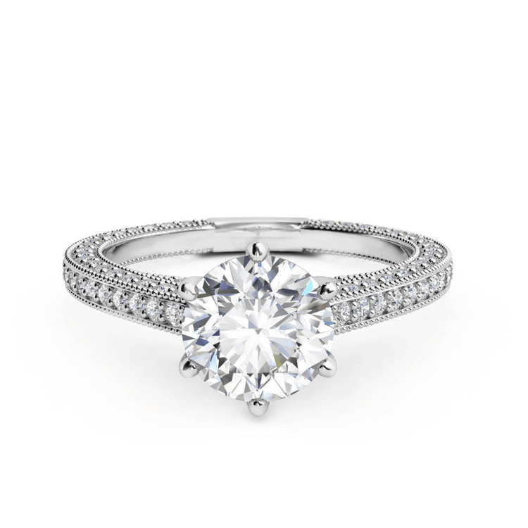 The 14k Round Lab Diamond Engagement Ring features a large round lab diamond in a prong setting with a split shank band adorned with pavé diamonds, offering timeless elegance for an unforgettable proposal.