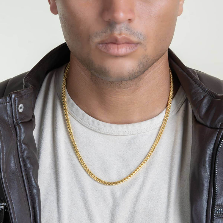 A model wears a white shirt, black leather jacket, and the Franco Chain - 3mm-3.5mm 14k Gold Bonded, shown from shoulders to lips against a plain background.