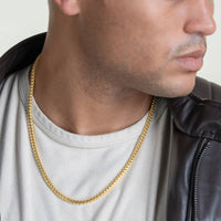 A person wearing a white shirt, black leather jacket, and the Franco Chain - 3mm-3.5mm 14k Gold Bonded necklace, shown from the shoulders up with their head slightly turned to the side.
