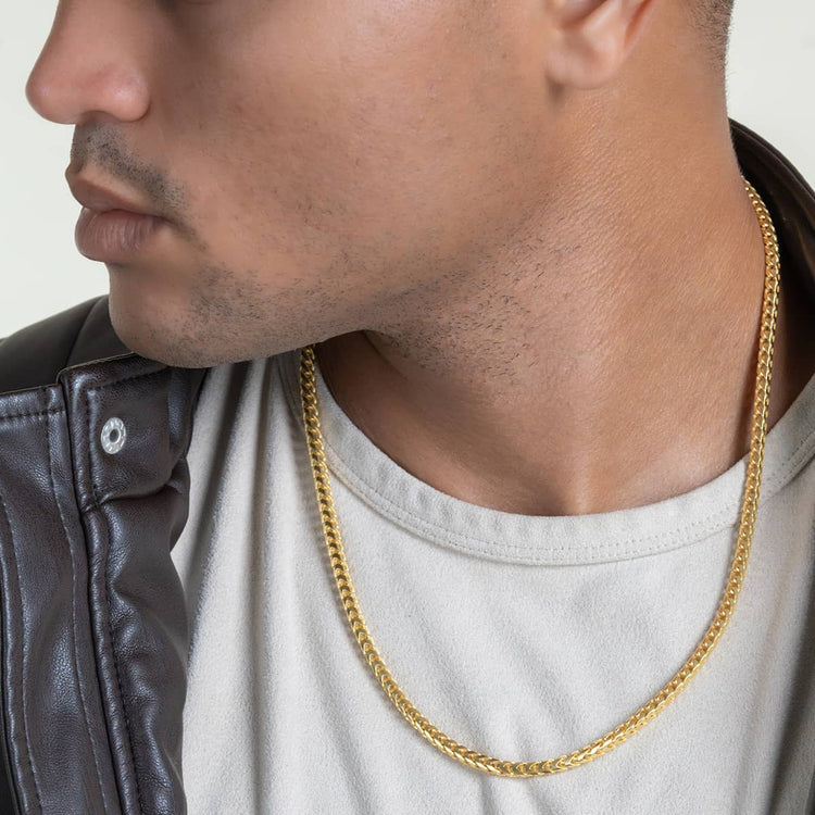 A man in a cream shirt and brown leather jacket looks to the side, showcasing the Franco Chain - 3mm-3.5mm 14k Gold Bonded necklace around his neck.