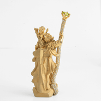 The Saint Christopher Pendant - 14k Gold features a robed figure holding a child and jeweled staff, adorned with sparkling stones and a green gem at the top, set against a plain white background.