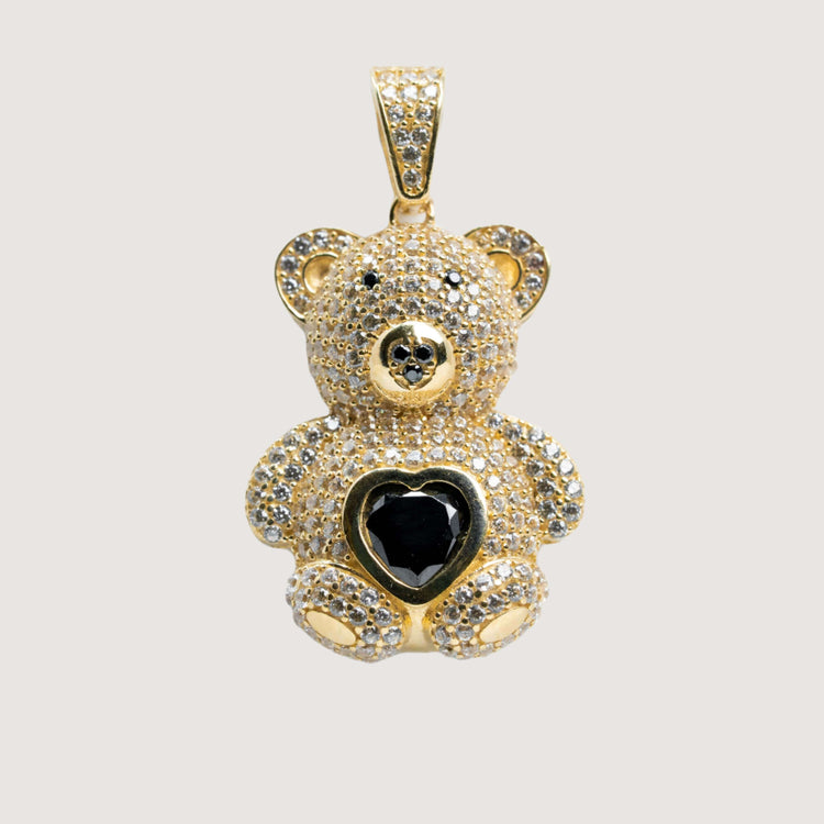 The 14k Yellow Gold Teddy Bear Pendant features clear gemstones and a striking black heart-shaped center gem, with a bail for easy attachment to your favorite chain.