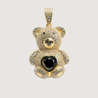 The 14k Yellow Gold Teddy Bear Pendant features clear gemstones and a striking black heart-shaped center gem, with a bail for easy attachment to your favorite chain.