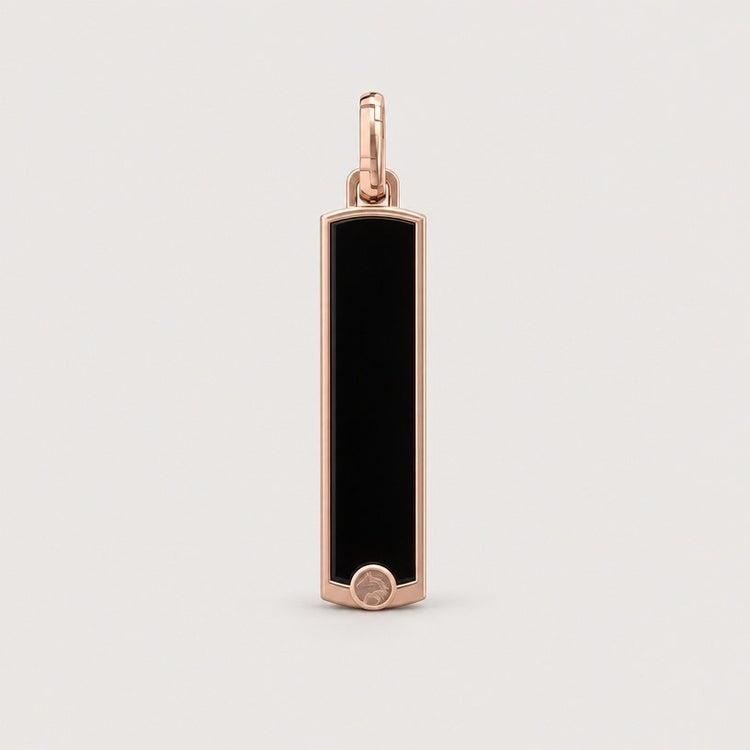 The 14k Gold Black Enamel Tag Pendant features a rectangular black enamel design accented with rose gold edges and finished with a small circular detail at the bottom, all set against a minimalist light background—an elegant piece crafted to elevate any look.
