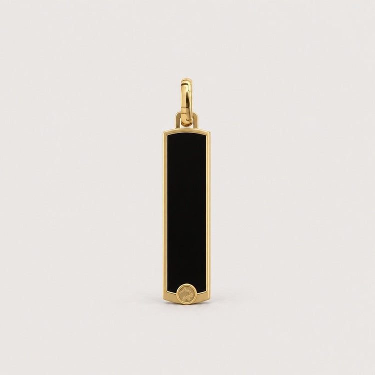 The 14k Gold Black Enamel Tag Pendant is a rectangular pendant featuring a black enamel inlay and a small circular gold detail at the bottom center, shown against a plain light background.