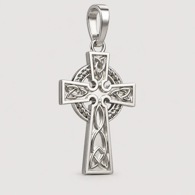 A 14k gold Celtic cross pendant featuring intricate knotwork and a circular motif behind the crossbar, displayed on a warm off-white studio background with a subtle contact shadow below.