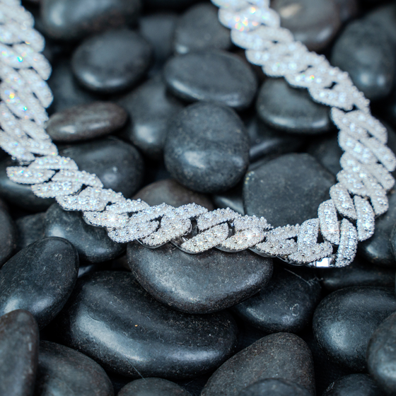 Shop 14mm Iced-Out Cuban Link Chain. Featuring 3 rows of Certified Moissanite Diamond Stimulants set in 925 Sterling Silver and Rhodium Plated. 