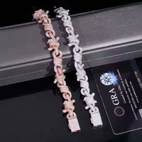 The Twisted Infinity Thorn Moissanite Bracelet (15mm) sparkles with moissanite stones and is shown beside a black GRA diamond certification card on a reflective surface.