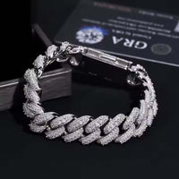 A close-up of the Silver Moissanite Cuban Link Bracelet - 16mm, crafted in 925 sterling silver and set with sparkling moissanites, displayed on a black surface with a certificate card partially visible in the background.