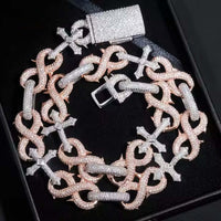 A close-up of the Two-Tone Cross Moissanite Necklace-16mm, featuring interlocking rose gold and silver links adorned with sparkling moissanites, elegantly displayed on a black surface.