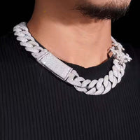 A person wears the 18mm Moissanite Cross Cuban Link Chain, crafted from thick 925 sterling silver with sparkling VVS moissanite stones, over a black ribbed shirt. Only the lower half of their face and neck are visible.