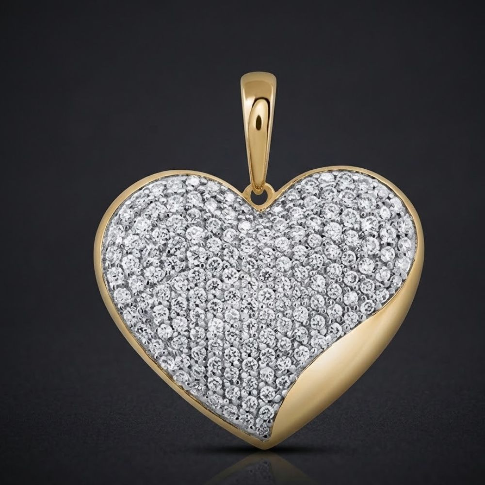 The 10K Yellow Gold 1 CTW Natural Diamond Heart Pendant features a heart-shaped design encrusted with natural diamonds and a smooth yellow gold accent on the lower right edge, set against a dark background.