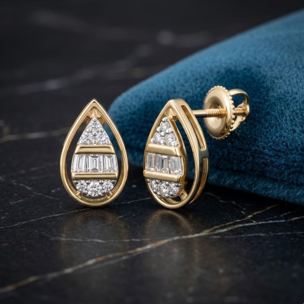 1/10 CTW Natural Diamond Pear Earrings in 10k Gold displayed on a dark marble surface beside a blue fabric pouch.