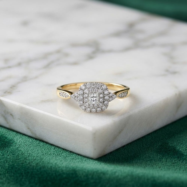 The 1/4 CTW Diamond Double Halo Engagement Ring is displayed on a white marble surface with a green cloth beneath.