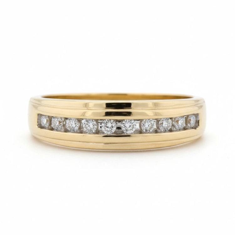 The 10k Yellow Gold Diamond Channel-Set Wedding Band 1/5 Ctw showcases a row of round white diamonds in a sleek channel setting on yellow gold, presented against a plain white background.
