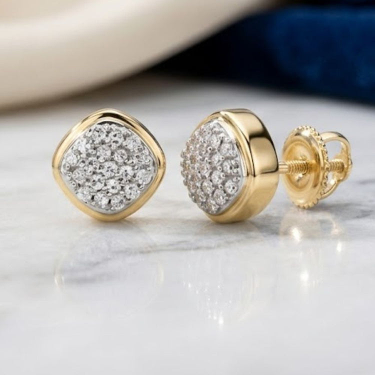 A pair of 1/10 CTW Diamond Cushion Earrings in 10k gold, featuring cushion-shaped settings adorned with natural white diamonds, displayed on a marble surface.