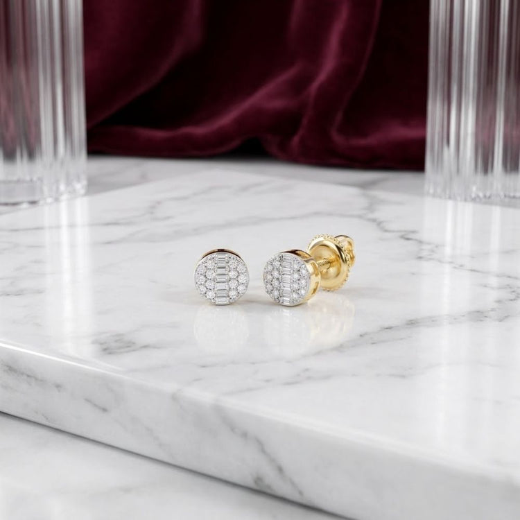 Gold and silver round cufflinks with a grid of small diamonds rest on a white marble surface, accompanied by the refined elegance of 10k Gold Round Diamond Stud Earrings 1/6 Cttw in the background, framed by glass columns and burgundy velvet.