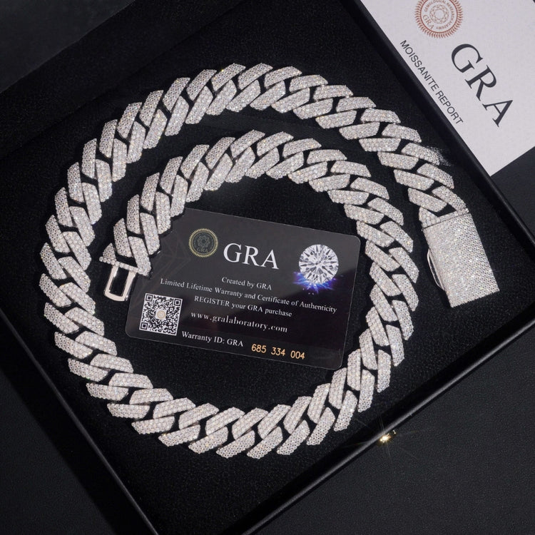 The Moissanite Cuban Links Chain 20mm, crafted from 925 sterling silver, is shown in a black box with a diamond-graphic GRA certificate card beside it and the edge of a GRA moissanite report also visible.
