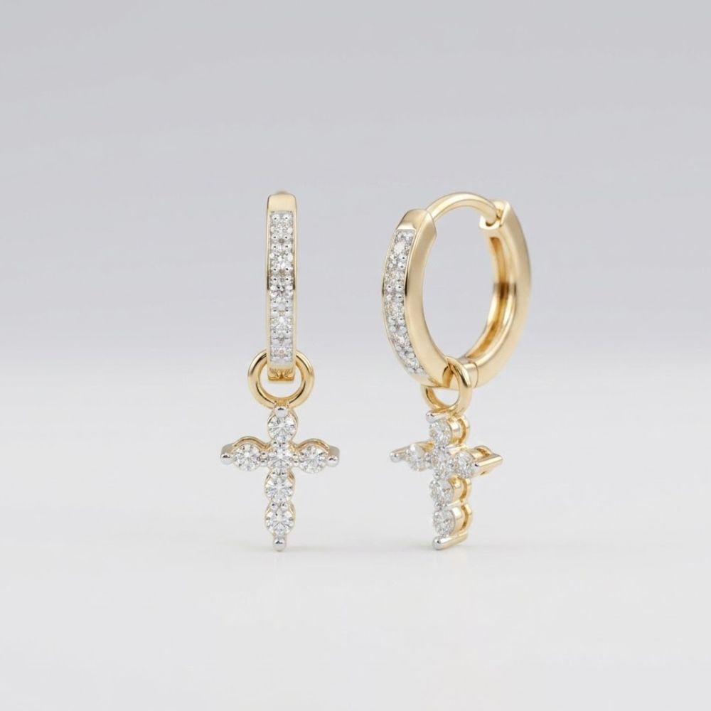 The 10k Yellow Gold Round Diamond Cross Hoop Dangle Earrings (1/8 Cttw) feature small diamond-encrusted cross charms for an elegant look, beautifully displayed against a plain light gray background.