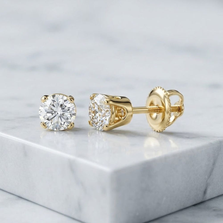 14k Gold Round Diamond Solitaire Earrings 5/8 CTW, shown with one earring viewed from the front and the other from the side to display the gold screw backing.