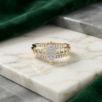 A 10k Gold Oval Diamond Cluster Bridal Ring, featuring 1/2 carat total weight of diamonds, is displayed on a marble surface with green velvet fabric draped in the background.