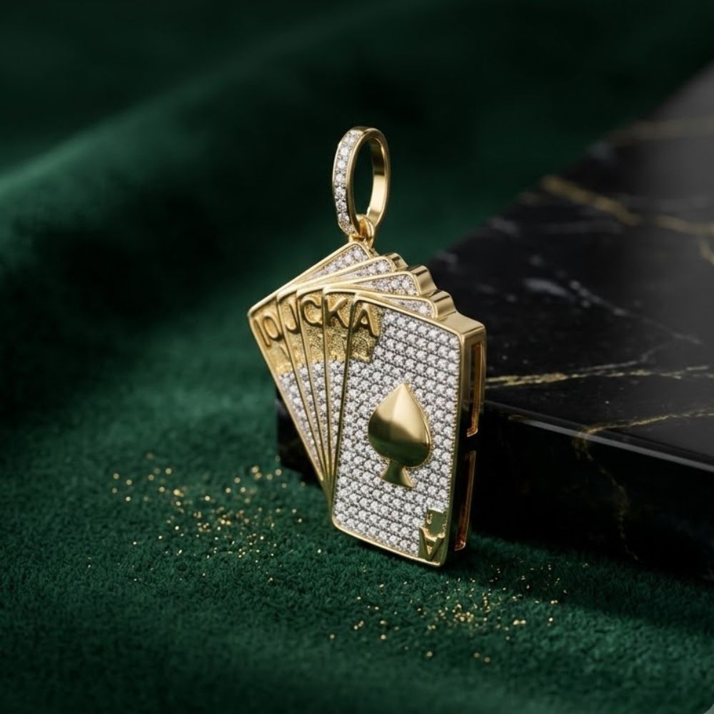The 10K Gold Diamond Royal Flush Pendant 5/8 CTTW, shaped like a fan of spade cards—10, J, Q, K, A—and adorned with diamonds, rests on dark green velvet by a black marble edge; a striking charm.