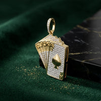 The 10K Gold Diamond Royal Flush Pendant 5/8 CTTW, shaped like a fan of spade cards—10, J, Q, K, A—and adorned with diamonds, rests on dark green velvet by a black marble edge; a striking charm.