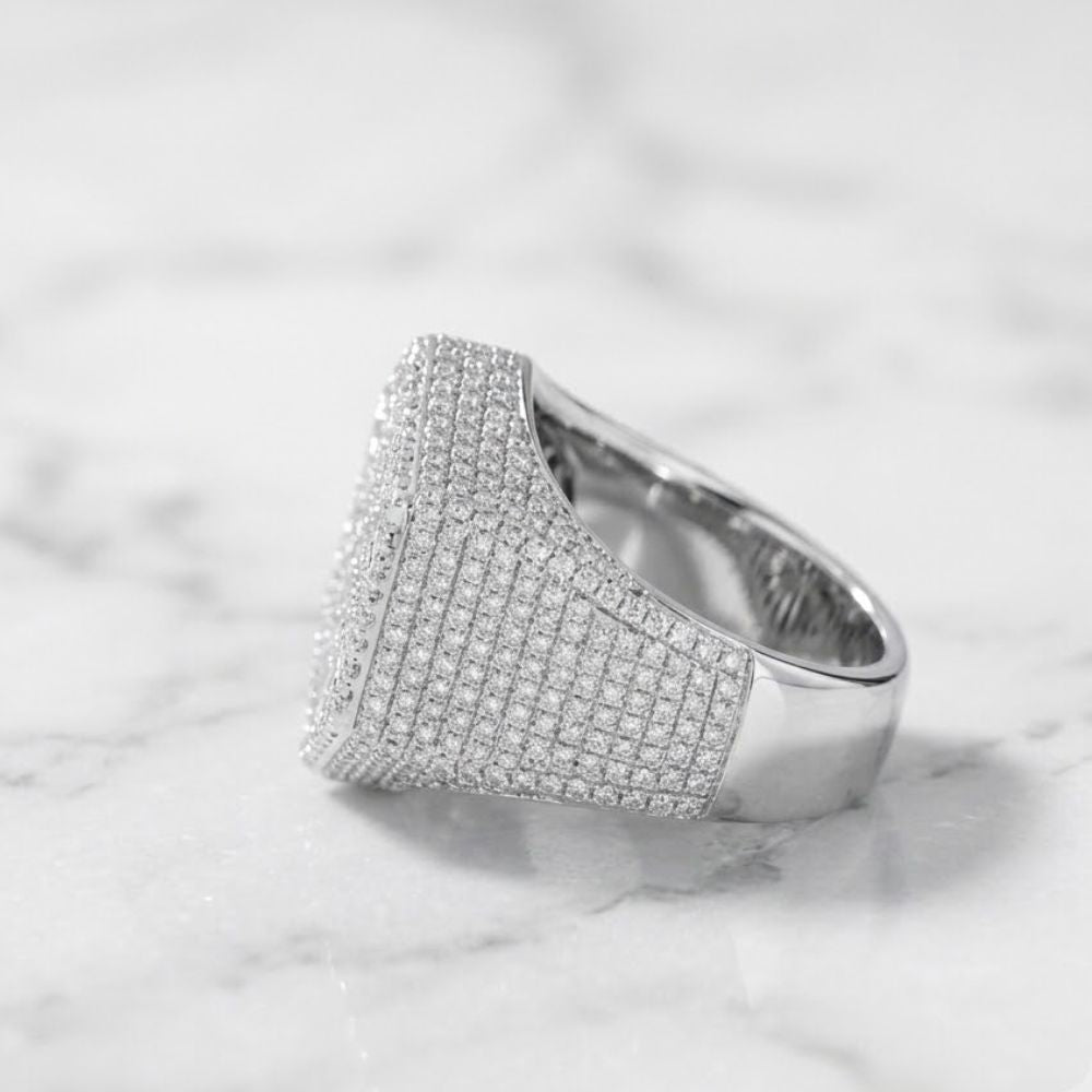 The 925 Silver Moissanite Snowflake Ring, featuring a wide sterling silver band set with sparkling moissanite stones, rests on white marble—a refined men’s fashion ring choice.