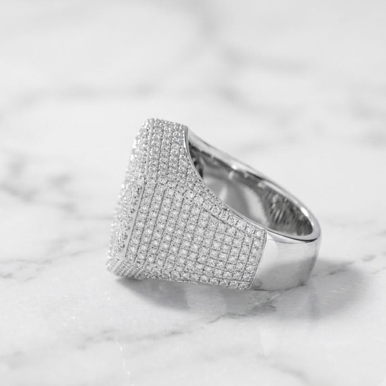 The 925 Silver Moissanite Snowflake Ring, featuring a wide sterling silver band set with sparkling moissanite stones, rests on white marble—a refined men’s fashion ring choice.