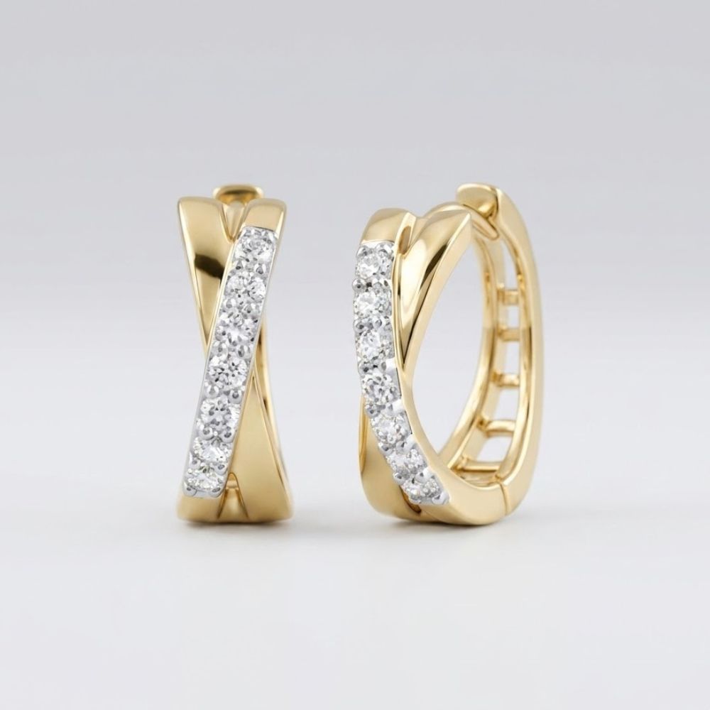 The 10k Gold Round Diamond Hoop Earrings – 1/6 Cttw feature a criss-cross design with sparkling white diamonds set along the front curve, shown upright against a simple light background.