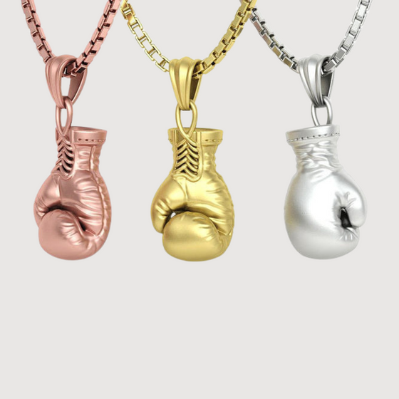 Rose, gold, and silver boxing glove pendants on chains, symbolizing strength and resilience in elegant design.