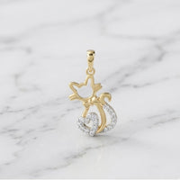 The 1/10 CTW Diamond Heart Cat Pendant in 10K Gold, shaped like a cat with a sparkling bow and tail, makes the perfect cat lover’s gift and looks stunning on a white marble display.