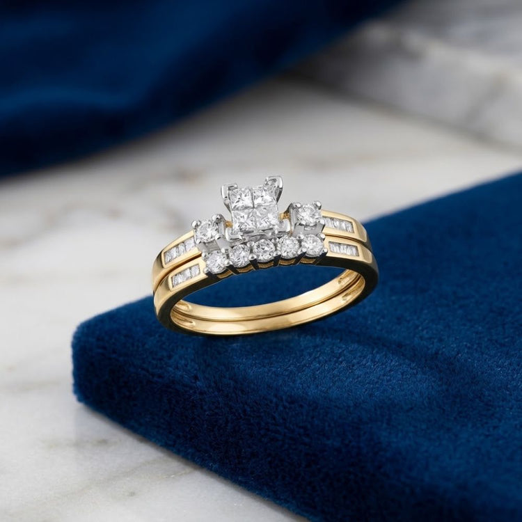 Introducing the 10k Gold Princess Diamond Bridal Ring Set 3/8 Cttw: This exquisite bridal set showcases a square-cut princess diamond at the center, complemented by several smaller diamonds totaling 3/8 carat total weight, all elegantly crafted in shimmering 10k white gold. Presented on a blue velvet surface with a marble backdrop, this ring set radiates timeless sophistication.