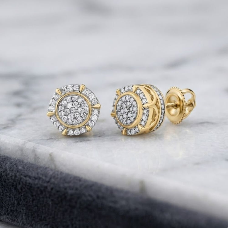 A pair of 1/4CTW Natural Diamond Gift Earrings in sterling silver, featuring circular clusters of small natural diamonds, is displayed on a marble surface. One earring presents the front view, while the other reveals the screw-back design, highlighting the timeless elegance of these natural diamond sterling silver earrings.
