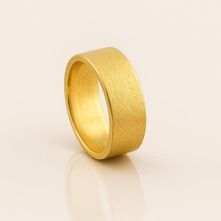 An 8mm Flat Band Ring - 24k is displayed on a white surface.