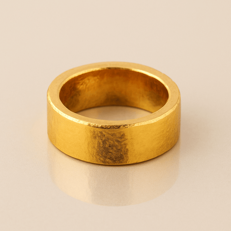 The 10mm 1oz Flat Band Ring-24k features a sleek flat band of pure gold, displayed on a white surface—an ideal choice for a minimalist wedding band.