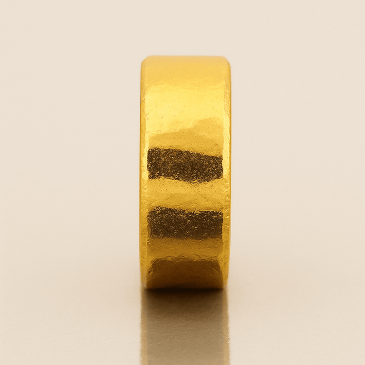 The 10mm 1oz Flat Band Ring-24k features a thick, matte-finished 24k gold design with smooth, faceted texture and bold geometry—an ideal minimalist wedding band shown upright on a neutral, reflective surface.