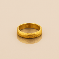 The 4mm, 24k Hammered Band Ring features a comfort-fit design and rests elegantly on a white surface.