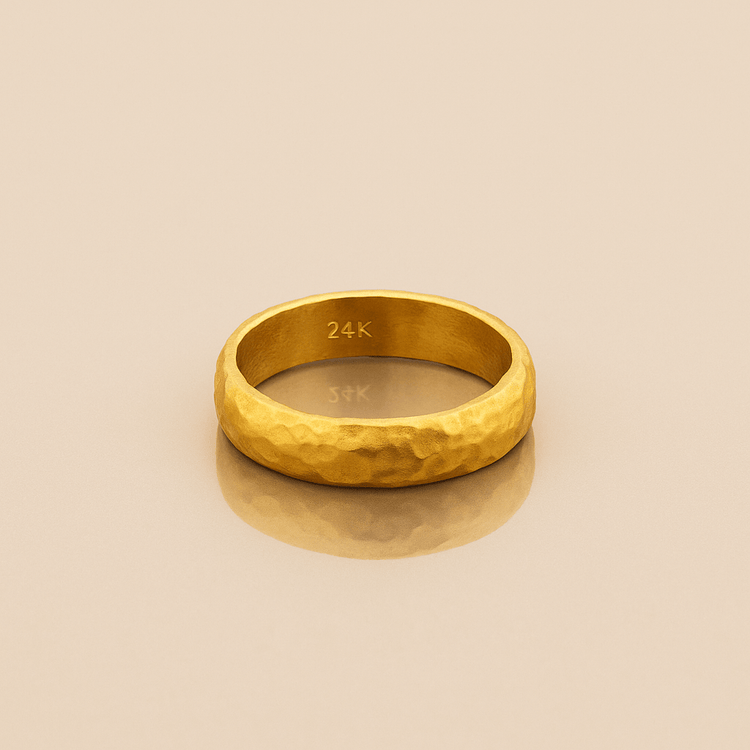 The 4mm, 24k Hammered Band Ring features a comfort-fit design and rests elegantly on a white surface.
