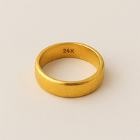 A 4mm, 24k Band Ring with “24K” engraved inside, featuring a plain polished design in a comfort-fit style, displayed on a neutral light background.