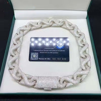 The Ice Out Silver Moissanite Cuban Link Chain - 20mm is a thick, diamond-encrusted necklace displayed in an open jewelry box with a GRA certificate card inside.