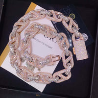 A gold and silver Cuban link diamond necklace with a sparkling padlock pendant sits on documents and a black box—ideal to pair with the Two Tone Moissanite Mariner Bracelet - 20mm.