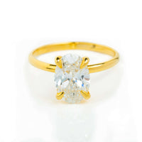 A 1.72ct oval-cut lab diamond engagement ring in 14k solid yellow gold is showcased elegantly against a white background.
