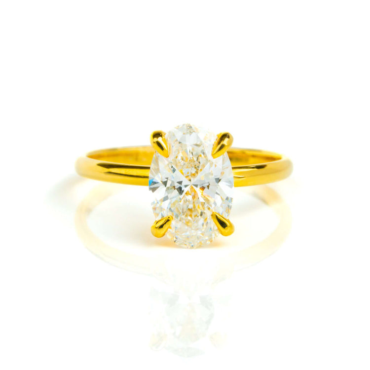 The 1.72ct oval-cut lab diamond engagement ring, set in 14k solid yellow gold, features a solitaire stone held by four prongs and is displayed on a white background.