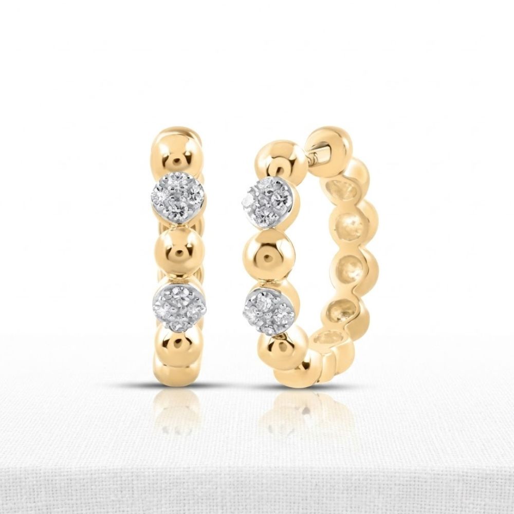 The 10K Diamond Hoop Earrings 1/10 CTTW Gold Hoops feature a beaded design with three round diamonds on each hoop, displayed upright on a light textured surface with a white background.