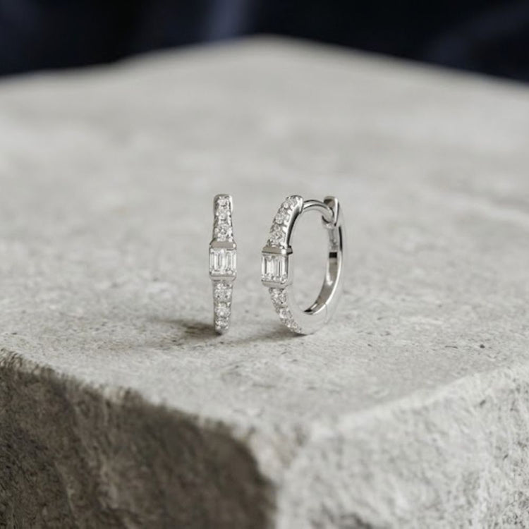 1/8CTW Natural Diamond Hoop Earrings 10K Gold: a pair of small 10K yellow gold hoop earrings, each featuring a centered baguette diamond flanked by natural diamond round accent stones.
