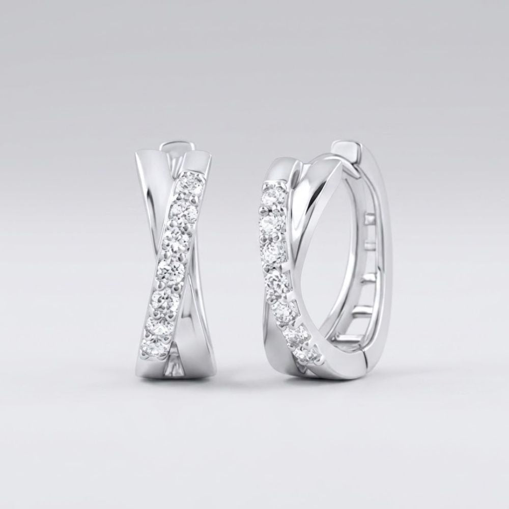 The 10k Gold Round Diamond Hoop Earrings – 1/6 Cttw showcase an elegant crisscross design with sparkling round diamonds set on the front, displayed against a plain light grey background.
